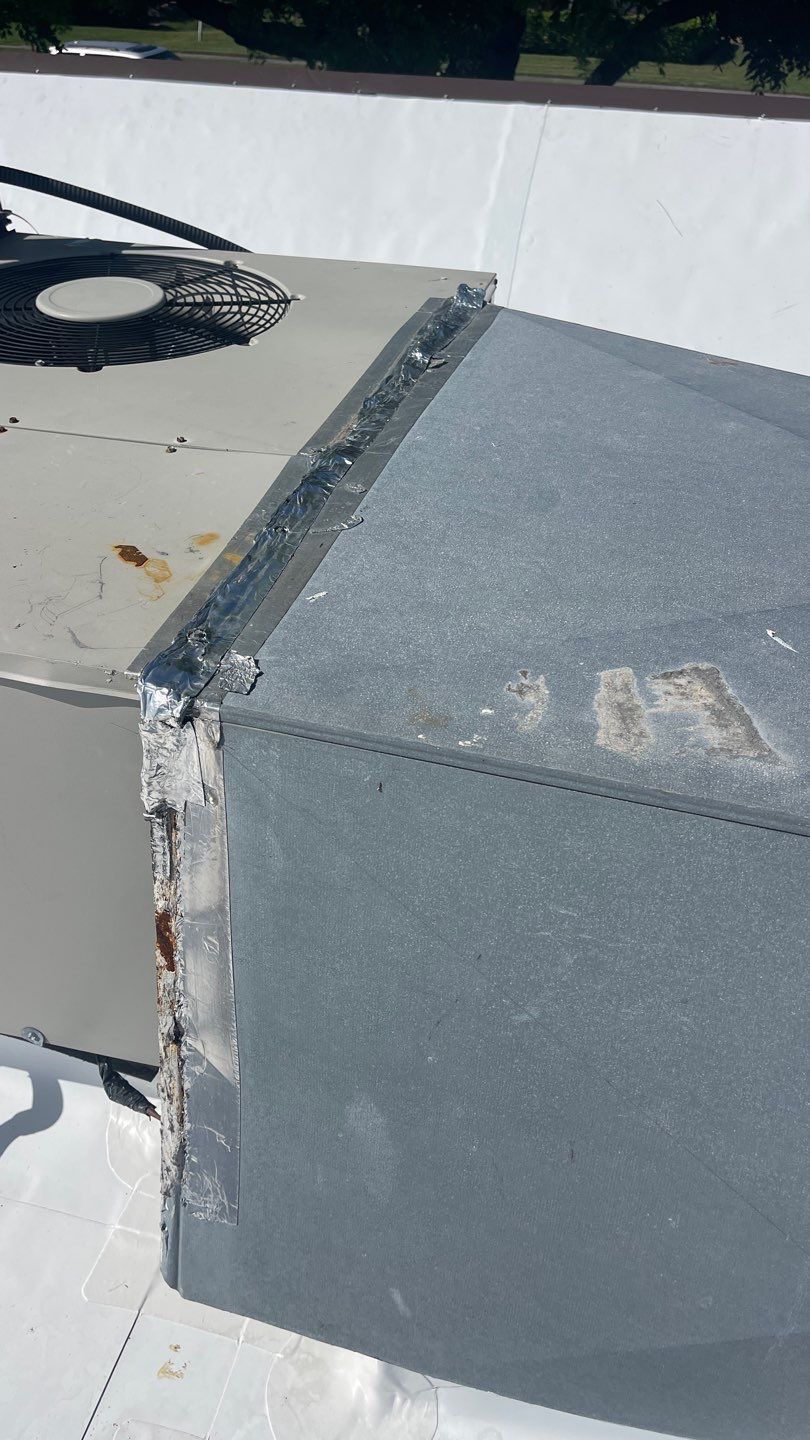 Flat roof with damaged HVAC unit requiring professional repair services