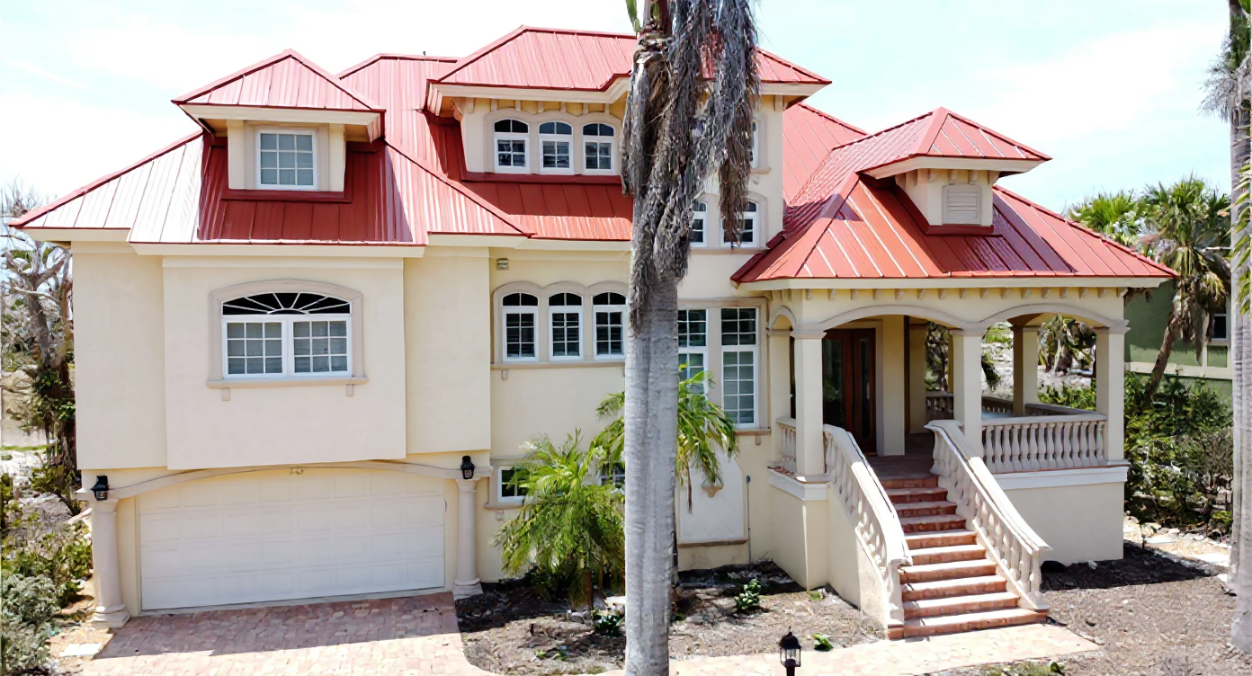 Completed luxury home renovation with distinctive red metal roofing system